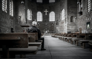 Photo of old man seated in empty church